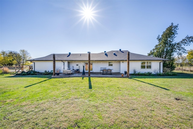 rear view of property featuring a lawn and a patio area