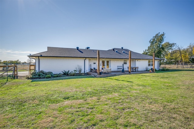 back of house featuring a patio area and a lawn