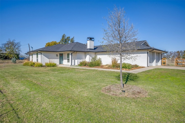 ranch-style house featuring a garage and a front lawn