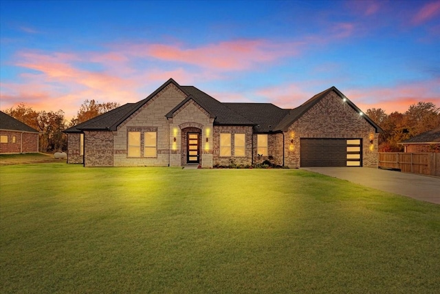 french country inspired facade with a lawn and a garage