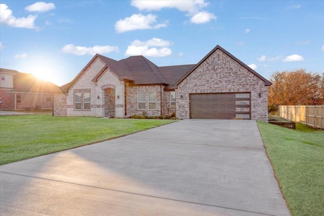 french country inspired facade with a garage and a front lawn