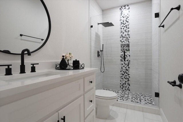 bathroom with tile patterned flooring, vanity, toilet, and tiled shower