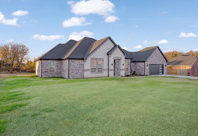 french provincial home featuring a front lawn and a garage