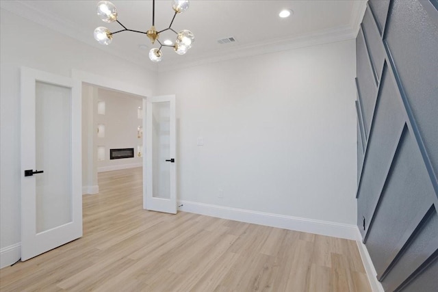 interior space with crown molding, a chandelier, and light wood-type flooring