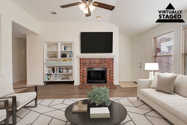 unfurnished living room featuring a fireplace, hardwood / wood-style floors, vaulted ceiling, and ceiling fan