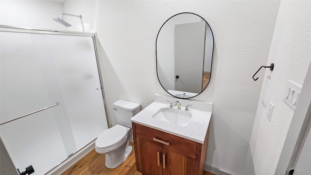 bathroom with walk in shower, toilet, vanity, and hardwood / wood-style flooring