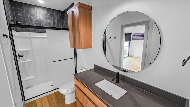 bathroom featuring toilet, a shower, wood-type flooring, and vanity