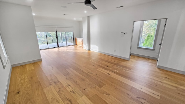 unfurnished living room featuring ceiling fan, vaulted ceiling, and light hardwood / wood-style flooring