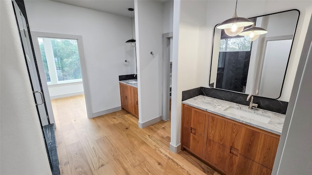 bathroom with wood-type flooring, vanity, and a notable chandelier