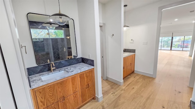 bathroom with vanity, hardwood / wood-style flooring, a wealth of natural light, and a shower with door