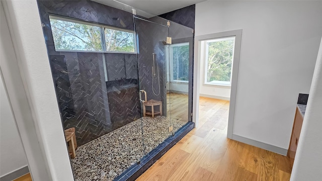 bathroom with hardwood / wood-style floors and a tile shower