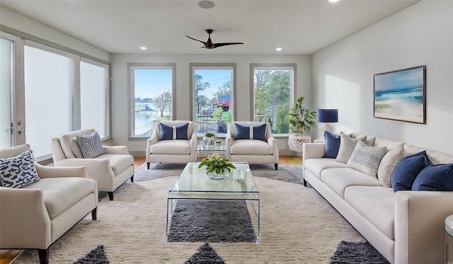 living room featuring ceiling fan and light hardwood / wood-style flooring