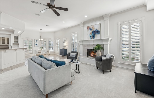 living room with light colored carpet, ceiling fan, ornamental molding, and sink