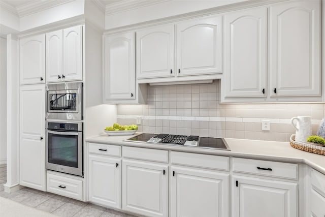 kitchen with white cabinets, ornamental molding, and appliances with stainless steel finishes