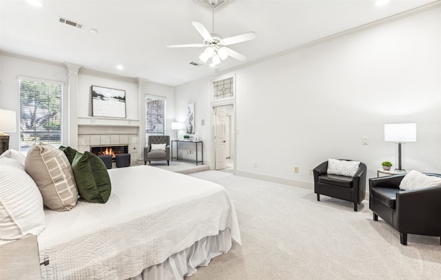 carpeted bedroom with ceiling fan, ornamental molding, and a tile fireplace