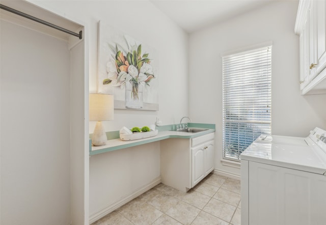 laundry area featuring sink, light tile patterned floors, washer and clothes dryer, and cabinets