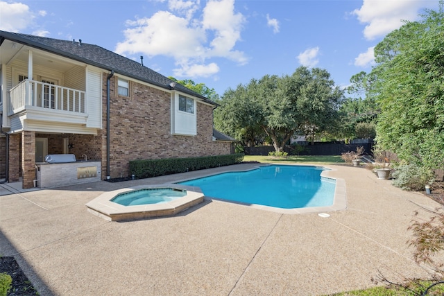 view of pool featuring a patio area, exterior kitchen, and an in ground hot tub