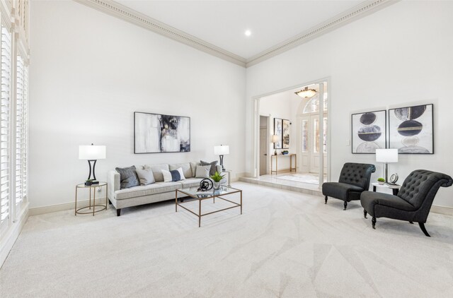 carpeted living room with crown molding and a high ceiling