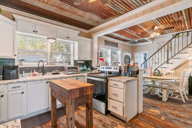 kitchen with electric stove, white cabinetry, plenty of natural light, and dark wood-type flooring