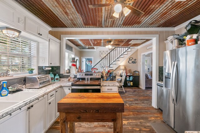 kitchen featuring butcher block countertops, dark hardwood / wood-style flooring, white cabinetry, and stainless steel appliances