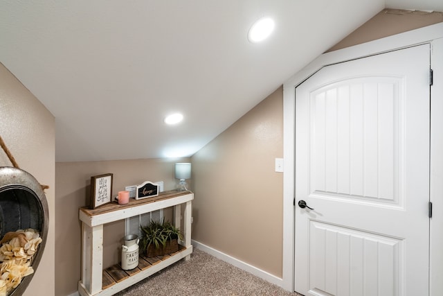 corridor with carpet and lofted ceiling