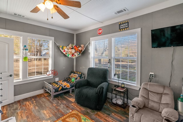 living area with ceiling fan, plenty of natural light, and dark hardwood / wood-style floors