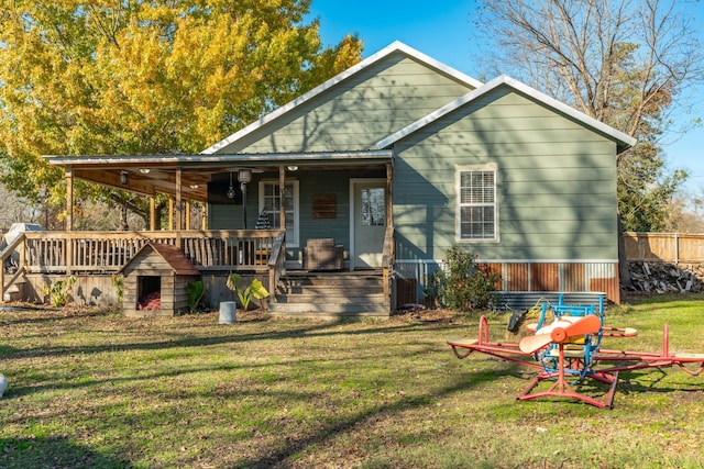 rear view of house featuring a porch and a lawn