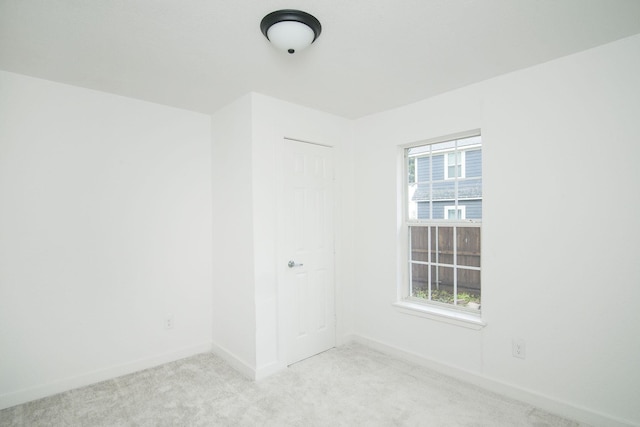 unfurnished room featuring light carpet