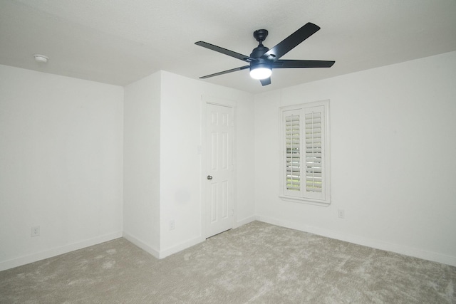 empty room featuring ceiling fan and light colored carpet