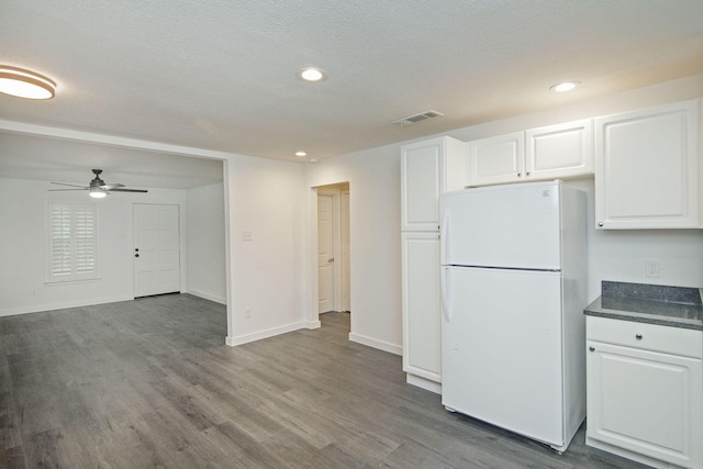 kitchen featuring hardwood / wood-style floors, white refrigerator, white cabinetry, and ceiling fan