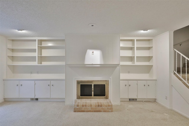 unfurnished living room with light carpet, a textured ceiling, and a brick fireplace