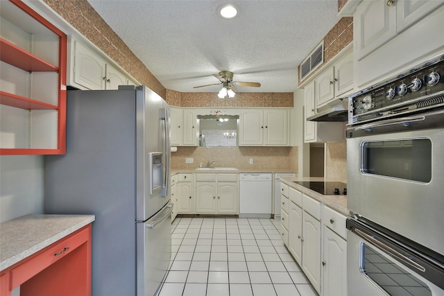 kitchen with ceiling fan, backsplash, stainless steel appliances, a textured ceiling, and light tile patterned flooring