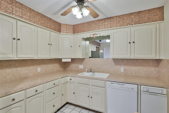 kitchen featuring light tile patterned flooring, sink, a textured ceiling, white dishwasher, and backsplash