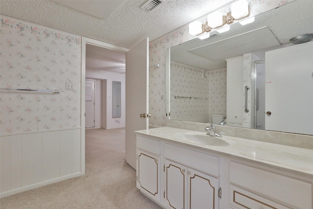 bathroom featuring vanity, a textured ceiling, and an enclosed shower