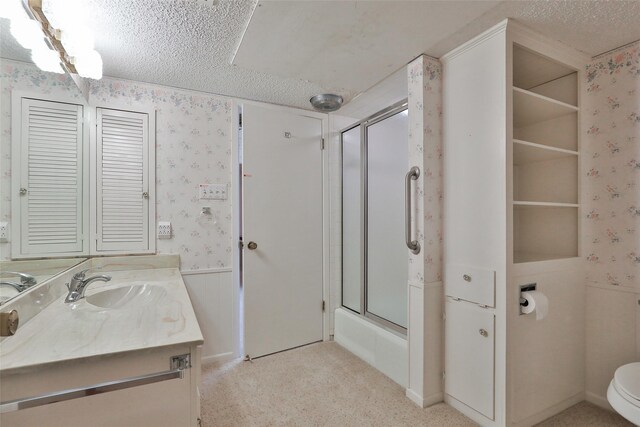 full bathroom featuring vanity, toilet, shower / bath combination with glass door, and a textured ceiling