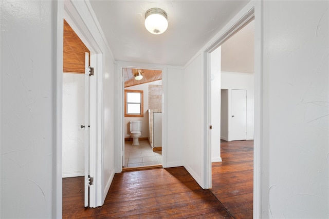 corridor featuring lofted ceiling and dark wood-type flooring