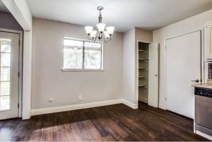 unfurnished dining area featuring plenty of natural light, dark hardwood / wood-style floors, and a chandelier