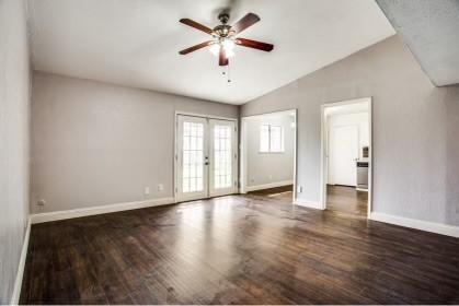 spare room featuring ceiling fan, french doors, dark wood-type flooring, and lofted ceiling