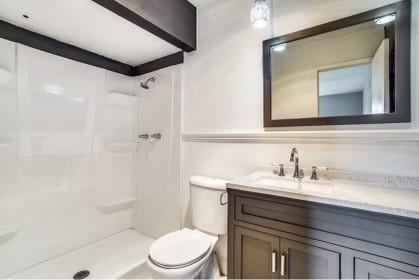 bathroom featuring a shower, vanity, and toilet