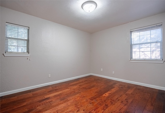 spare room with dark wood-type flooring