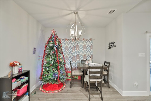 dining area with an inviting chandelier and light wood-type flooring