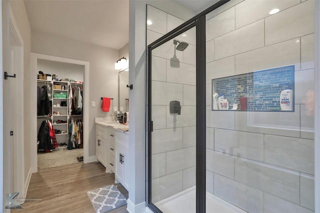 bathroom featuring vanity, hardwood / wood-style flooring, and a shower with shower door