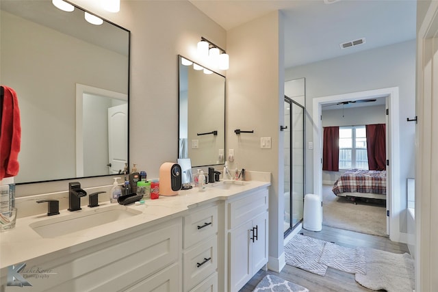 bathroom featuring vanity, hardwood / wood-style floors, and a shower with door