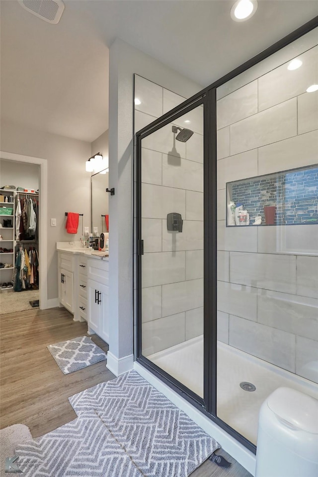 bathroom featuring vanity, hardwood / wood-style floors, and walk in shower