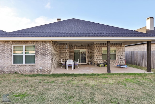 rear view of property with a lawn and a patio