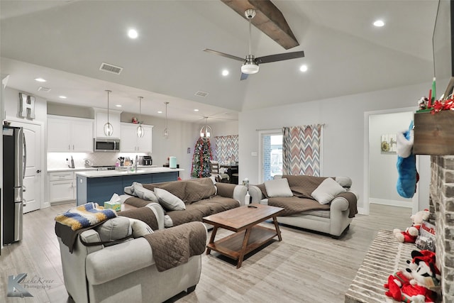 living room featuring ceiling fan, beam ceiling, high vaulted ceiling, and light wood-type flooring