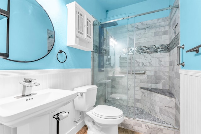 bathroom with sink, an enclosed shower, and toilet