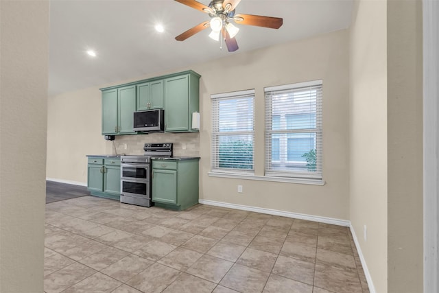 kitchen featuring light tile patterned floors, ceiling fan, green cabinets, stainless steel appliances, and tasteful backsplash