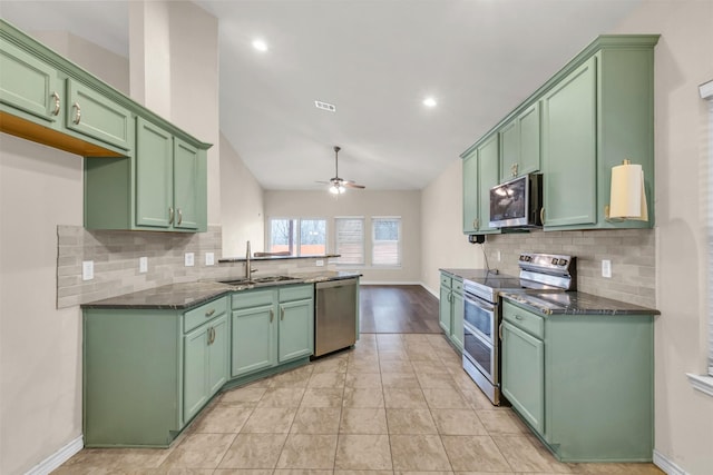 kitchen featuring sink, ceiling fan, green cabinets, appliances with stainless steel finishes, and dark stone counters