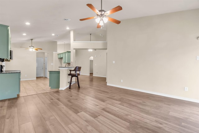 interior space with high vaulted ceiling, light hardwood / wood-style floors, and ceiling fan